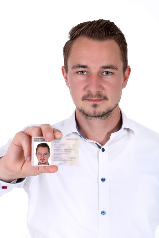 Mann zeigt seinen Personalausweis mit Passfoto Porträt