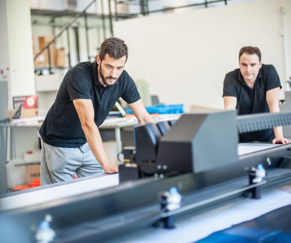 Professional worker printmaker technician operator works in modern printing plant