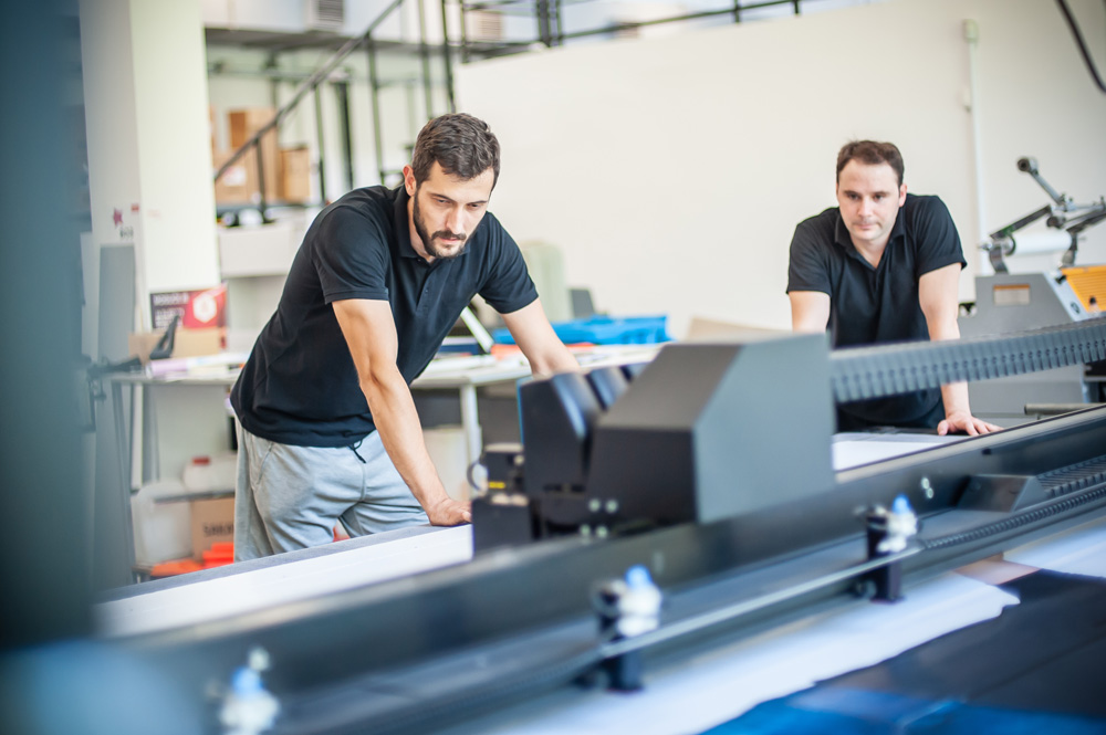 Professional worker printmaker technician operator works in modern printing plant