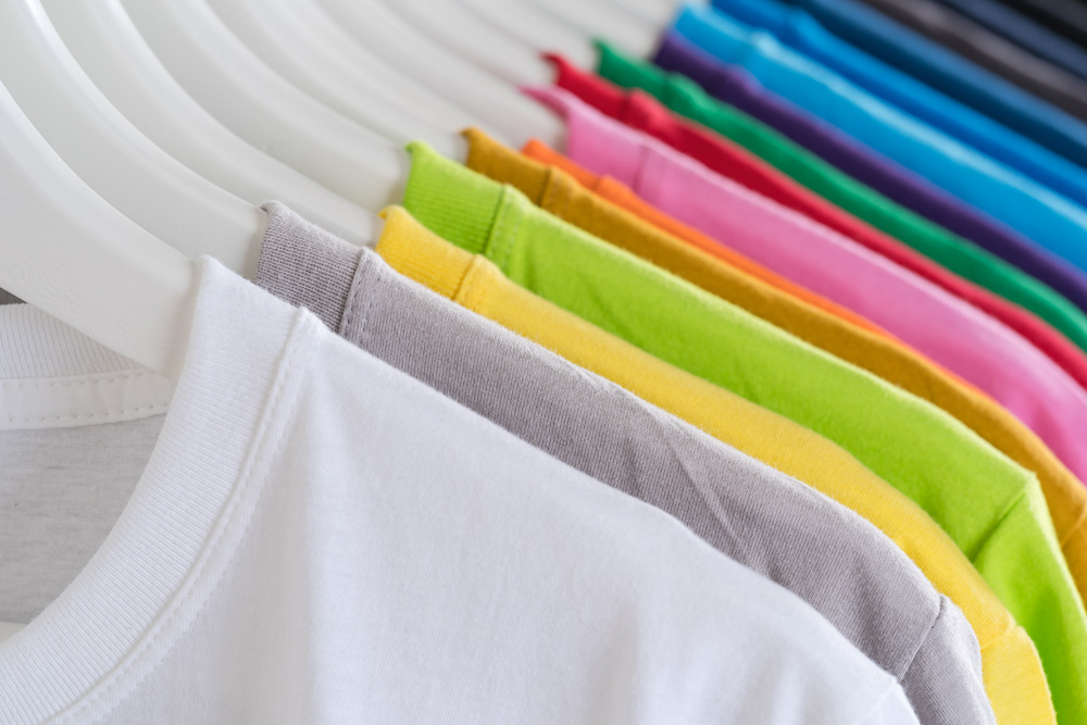 Close Up of t-shirts, Clothes on hangers on white background Close Up of t-shirts, Clothes on hangers on white background